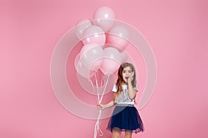 Child girl posing with pastel pink air balloons