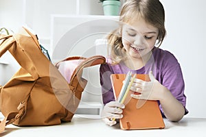 Child girl preparing to school. Back to school, supplies. Pupil with backpack