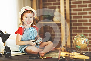 Child girl preparing to travel with a card and photo camera