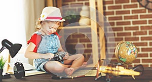 Child girl preparing to travel with a card and photo camera