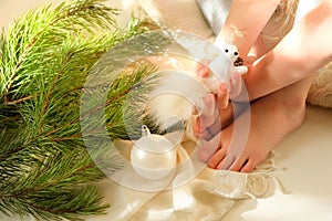 Child girl preparing  winter holidays and Christmas at home. She sitting on floor and playing with Christmas toys