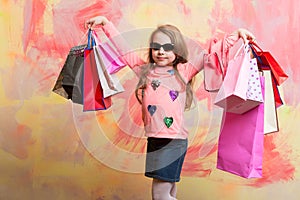 Child girl with present pack on colorful background.