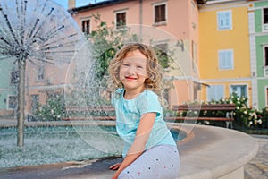 Child girl relaxing at fountain in Izola (Isola) city in Slovenia.