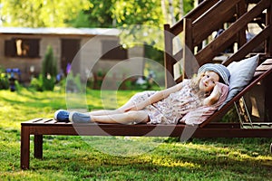 Child girl relaxing on sunbed in sunny garden