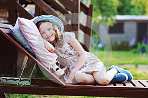 Child girl relaxing on sunbed in sunny garden photo