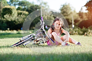 Child girl riding bicycle on summer sunset in the park.