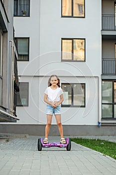 Child girl riding in on gyroscooter. Hobbies and active lifestyle in city