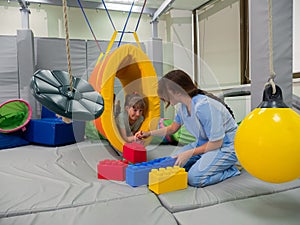 Child girl in roller tonnel during sensory integration session