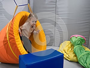 Child girl in roller tonnel during sensory integration session