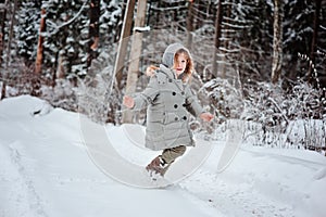 Child girl running in winter snowy forest