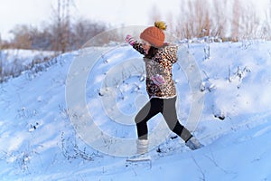 Child girl runs and having fun in the winter forest, bright sunlight and shadows on the snow, beautiful nature