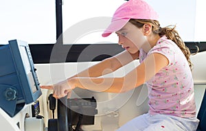 Child girl sailing steering the boat wheel