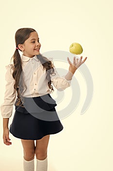 Child girl school uniform clothes toss apple. Girl cute pupil holds apple fruit white background. Child smart kid