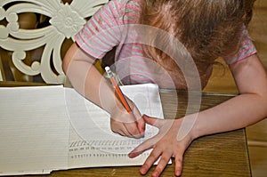 Child girl, schoolgirl doing homework.