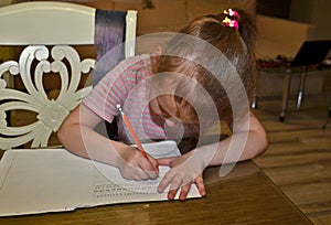 Child girl, schoolgirl doing homework.
