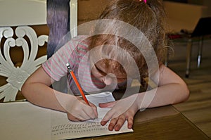 Child girl, schoolgirl doing homework.