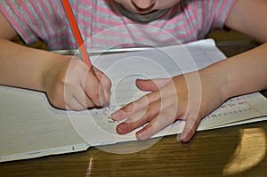 Child girl, schoolgirl doing homework.