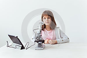 Child girl in science class using digital microscope. Technologies, children and learning concept.