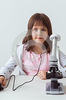 Child girl in science class using digital microscope. Technologies, children and learning concept.