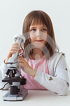 Child girl in science class using digital microscope. Technologies, children and learning concept.