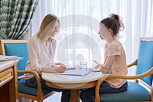 Child girl at session with social worker, school psychologist in office