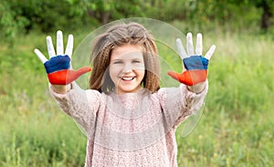 Child girl show hands painted in Russia flag colors walking outdoor. Day of Russian flag. Patriots citizens nationality