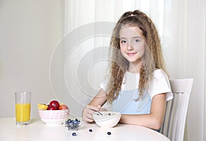 Child girl sitting at table and have a meal.Healthy nutrition concept.Morning breakfast.Young girl eating