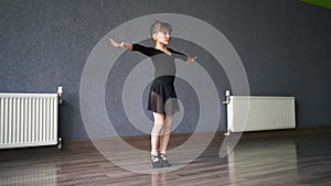 Child girl standing in black sport bodysuit in dancing studio during training posture. 4 5 years old preschool age