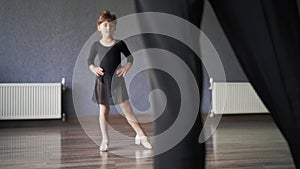 Child girl standing in black sport bodysuit in dancing studio during training posture. 4 5 years old preschool age