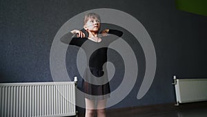 Child girl standing in black sport bodysuit in dancing studio during training posture. 4 5 years old preschool age