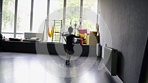 Child girl standing in black sport bodysuit in dancing studio during training posture. 4 5 years old preschool age