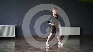 Child girl standing in black sport bodysuit in dancing studio during training posture. 4 5 years old preschool age