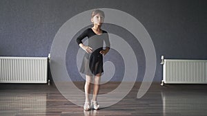 Child girl standing in black sport bodysuit in dancing studio during training posture. 4 5 years old preschool age