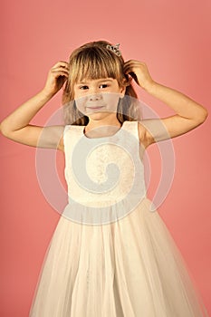 Child girl in stylish glamour dress, elegance. Fashion and beauty, little princess. Fashion model on pink background