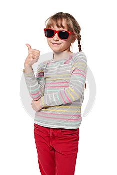 Child girl in sunglasses gesturing thumb up