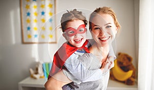 Child girl in a super hero costume with mask and red cloak