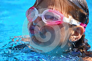 Child  girl swimmer in the pool. Sporting  healthy summer vacation with the kids.