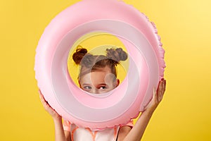 child girl in swimwear with inflatable rubber ring