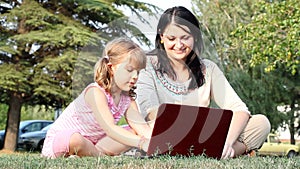 Child and girl typing on laptop