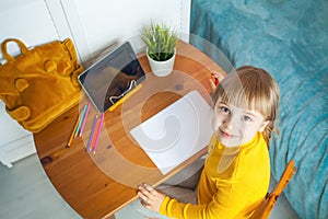 Child girl using tablet and drawing at home