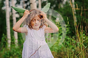 Child girl on the walk in summer forest, nature exploration with kids