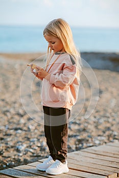 Child girl walking with camera outdoor on beach kid 4 years old family lifestyle