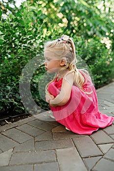 Child girl walks and have fun outdoor with cochlear implant on the head. Hearing aid and treatment concept. Copy space