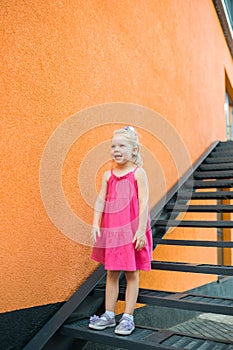 Child girl walks and have fun outdoor with cochlear implant on the head. Hearing aid and treatment concept. Inclusion