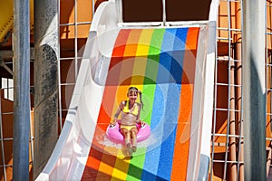 Child girl on water slide at aquapark