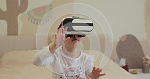 Child girl wearing virtual reality headset interacting with digital world, curious kid exploring universe with vr