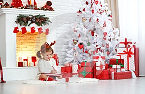 Child girl writing letter santa home near Christmas tree