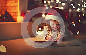 Child girl writing letter santa home near Christmas tree