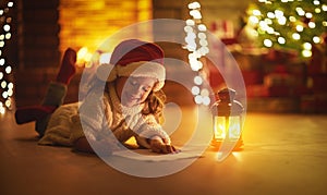 Child girl writing letter santa home near Christmas tree