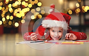 Child girl writing letter santa home near Christmas tree